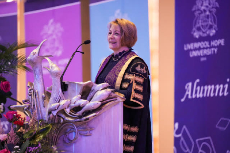 Professor Claire Ozanne addresses the congregation from a lectern at Liverpool Metropolitan Cathedral.